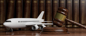 Model of airplane next to gavel with books in background.